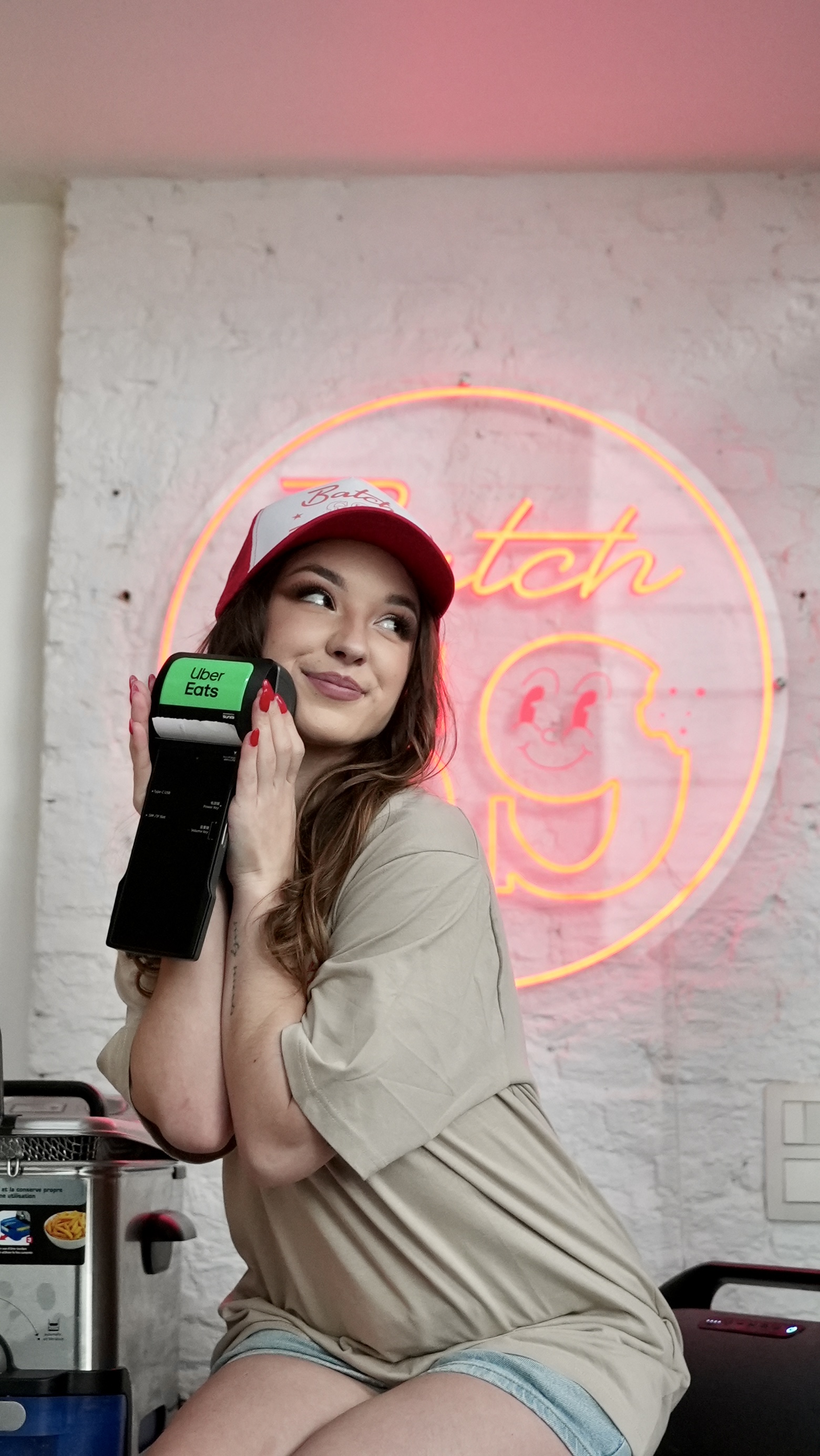 Batch69 neon sign glowing in the store — the iconic circle logo in coral red